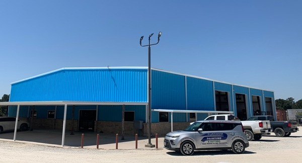 A painted blue building with cars parked nearby