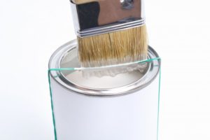 can of off-white paint with brush