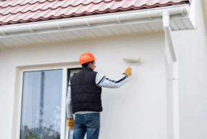 a person painting the exterior of their home